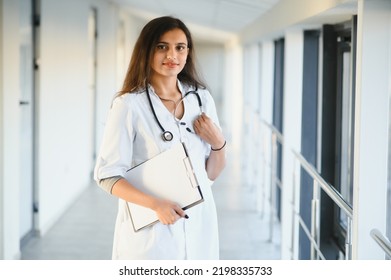 An Indian Asian Female Medical Doctor In A Hospital Office With Stethoscope.