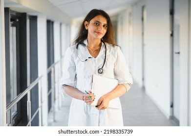 An Indian Asian Female Medical Doctor In A Hospital Office With Stethoscope.