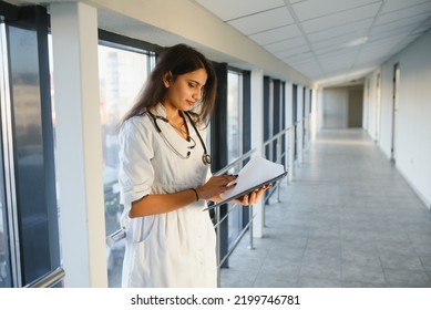 An Indian Asian Female Medical Doctor In A Hospital Office With Stethoscope.