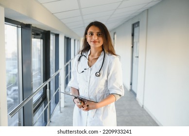 An Indian Asian Female Medical Doctor In A Hospital Office With Stethoscope.