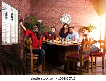 Indian Asian Friends Eating In Restaurant Dining Concept Wearing Protective Face Mask After Corona Pandemic