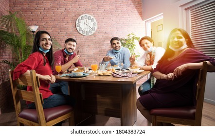 Indian Asian Friends Eating In Restaurant Dining Concept Wearing Protective Face Mask After Corona Pandemic