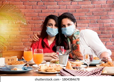 Indian Asian Friends Eating In Restaurant Dining Concept Wearing Protective Face Mask After Corona Pandemic