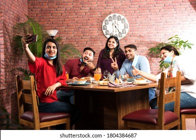 Indian Asian Friends Eating In Restaurant Dining Concept Wearing Protective Face Mask After Corona Pandemic