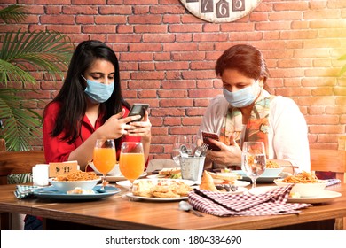 Indian Asian Friends Eating In Restaurant Dining Concept Wearing Protective Face Mask After Corona Pandemic