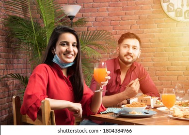 Indian Asian Friends Eating In Restaurant Dining Concept Wearing Protective Face Mask After Corona Pandemic