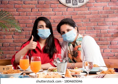 Indian Asian Friends Eating In Restaurant Dining Concept Wearing Protective Face Mask After Corona Pandemic