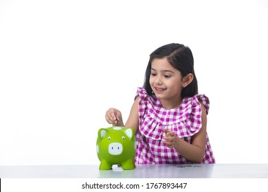 Indian, Asian Kid Girl With Piggy Bank, Saving Money And Smiling