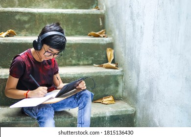 Indian / Asian Little Boy Studying Online Using Mobile Phone At Home