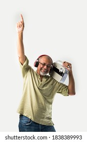 Indian Asian Old Man Or Male Senior Adult Listening To Music On Vintage Radio Using Headphones And Dancing, Isolated Against White Background