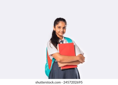 Indian asian schoolgirl in school uniform standing with books against white - Powered by Shutterstock