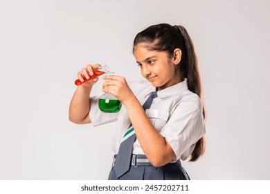 Indian asian schoolgirl in school uniform doing science experiment with chemical in flask - Powered by Shutterstock