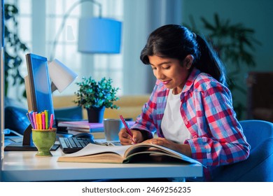 Indian asian teenage girl studying at home using personal computer, home education concept - Powered by Shutterstock