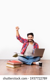 Indian Asian University Or College Student Sitting With Laptop Computer With Books On Wooden Floor Against White Background