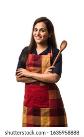 Indian / asian woman chef wearing Apron and holding wooden spatula while standing isolated over white background