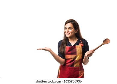 Indian / asian woman chef wearing Apron and holding wooden spatula while standing isolated over white background - Powered by Shutterstock