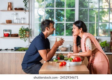 Indian asian young couple having tea or coffee in the kitchen - Powered by Shutterstock