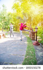 Indian Asian Young Couple Jogging, Running, Exercising Or Stretching Outdoors In Park Or Nature