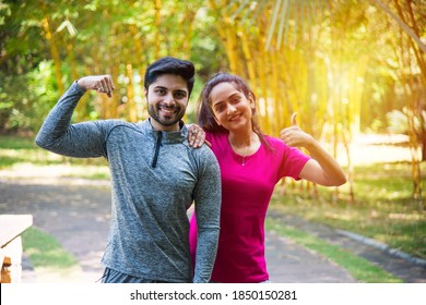 Indian Asian Young Couple Jogging, Running, Exercising Or Stretching Outdoors In Park Or Nature