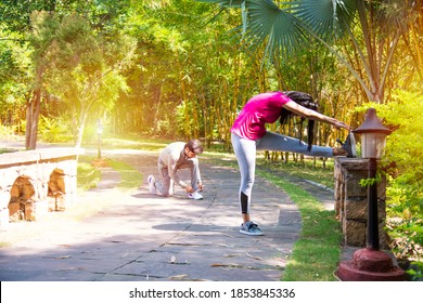 Indian Asian Young Couple Jogging, Running, Exercising Or Stretching Outdoors In Park Or Nature