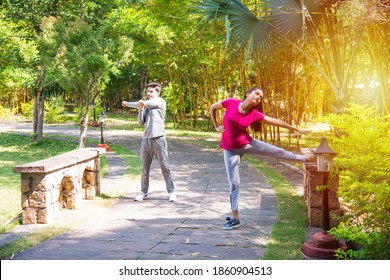 Indian Asian Young Couple Jogging, Running, Exercising Or Stretching Outdoors In Park Or Nature