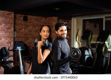 Indian Asian Young Couple Is Working Out In The Gym. Attractive Woman And Handsome Fit Man Are Training In Modern Gym - Health And Fitness Concept