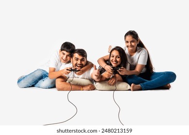 Indian asian young family of for consists parents and kids playing video games with remorte lying on white floor isolated - Powered by Shutterstock