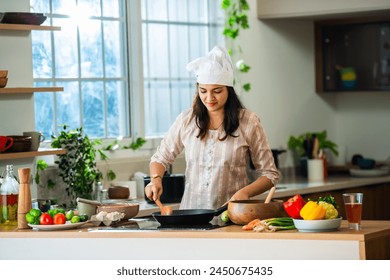 Indian asian young woman enjoy cooking healthy meal in modern kitchen - Powered by Shutterstock