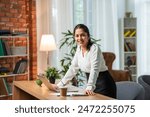 Indian asian young working professional female working on laptop at home wears smart formals