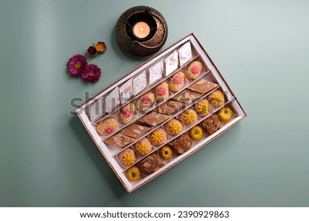 Indian assorted Diwali sweets or mithai box with diya and flowers. Festive gift idea. Kaju katli, dry fruits peda, barfi, cashew nut barfi, marzipan, khoya cakes. christmas box. copy space.
