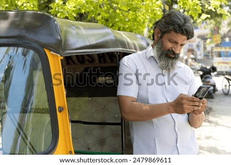 Indian auto driver using mobile phone