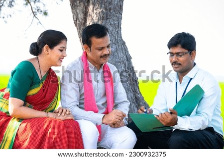 Indian banker explaining agri loan scheme to farmer village couple while sitting on farmland - concept of expertise, banking support and investment consultation