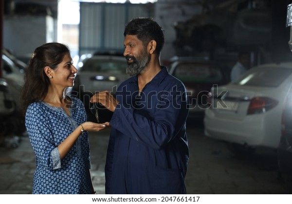 Indian\
bearded car mechanic delivering the car keys to the happy customer.\
Portraying customer satisfaction to the whole scene the joyful car\
specialist is returning the keys after car\
repair.