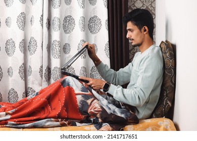 Indian Bearded Young Man Opening Laptop For Start Office Work Or Video Call Getting Ready For Work In The Morning At The Bed Near Window In A Beautiful House Starting Of A Work Day