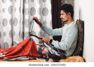 Indian Bearded Young Man Opening Laptop For Start Office Work Or Video Call Getting Ready For Work In The Morning At The Bed Near Window In A Beautiful House Starting Of A Work Day