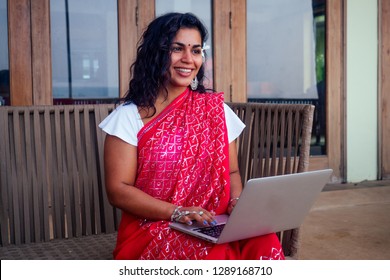 Indian Beautiful Businesswoman Working On A Modern Laptop In The Cafe Restaurant On The Shore Of The Paradise Ocean.Web Designer Girl Freelancer In India In The Sea .remote Work ,concept Copywriter