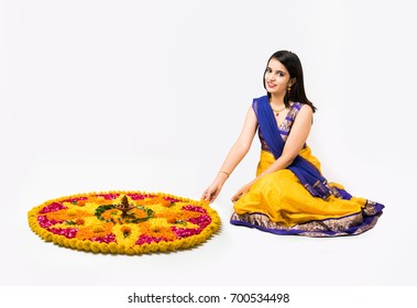 Indian Beautiful Young Girl Making Flower Rangoli For Diwali Or Onam Or Pongal Festival, Isolated Over White Background