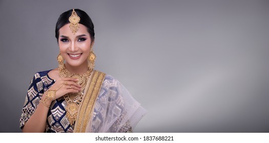 Indian beauty eyes with perfect make up wedding bride, Portrait of a beautiful woman in traditional ethnic Pakistani bridal costume with heavy jewellery, gray background banner copy space