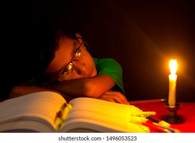 Indian boy with books in candlelight
