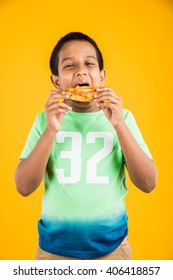 Indian Boy Eating Pizza Over Yellow Background