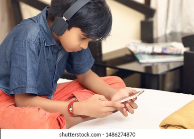 Indian Boy Enjoying Watching Something On Phone