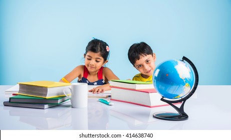 Indian Boy And Girl Studying With Globe On Study Table, Asian Kids Studying, Indian Kids Studying Geography, Kids Doing Homework Or Home Work, Two Kids Studying On Table