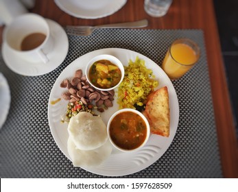 Indian Breakfast In An Hotel In India, Indian Breakfast With Idlis, Sambhar, Chutney, Poha, Orange Juice.