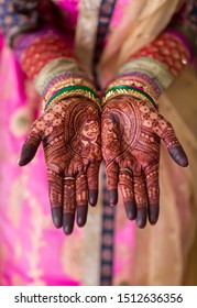 Indian Bridal wearing wedding bangles and showing mehndi design