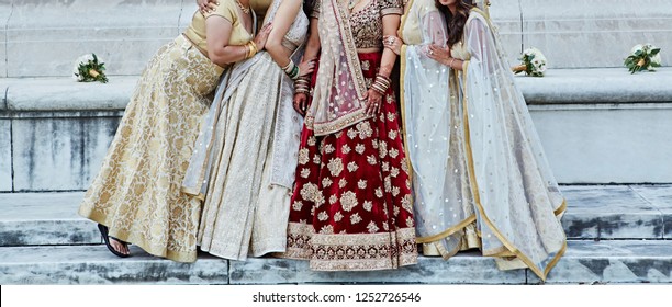 Indian bride with bridesmaids showing wedding dress