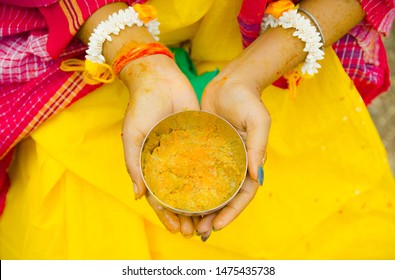 Indian Bride holding Turmeric paste or haldi paste in hand in a Hindu wedding ceremony.