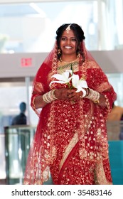 An Indian Bride In A Red Sari Walks Down The Aisle