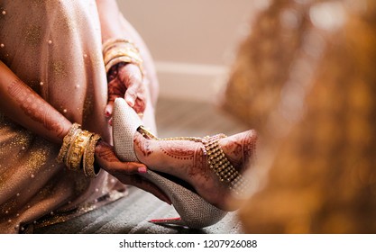 Indian Bridesmaid Of The Bride Helps Wearing Wedding Shoes