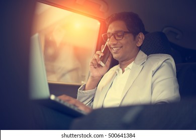 Indian Business Male Using Laptop And Phone Inside The Car

