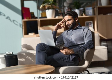 Indian Business Man Executive Working On Laptop Sitting On Chair In Modern Office. Eastern Male Entrepreneur Using Computer Remote Studying, Virtual Training, Watching Online Education Webinar.